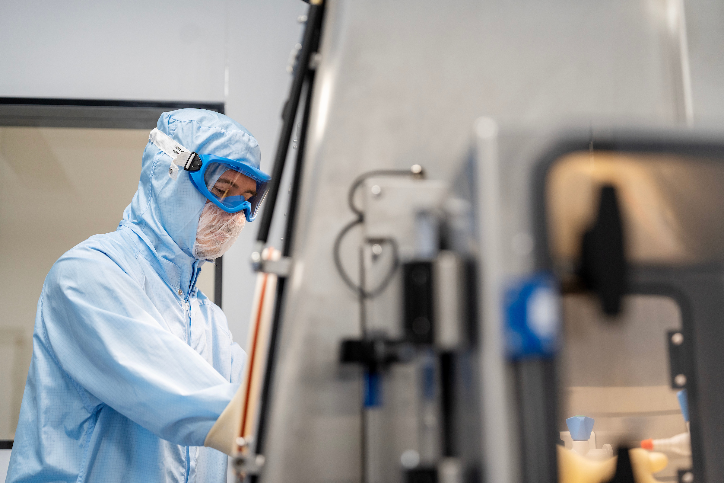 Sterile-finish isolator image with scientist working on biotech project.